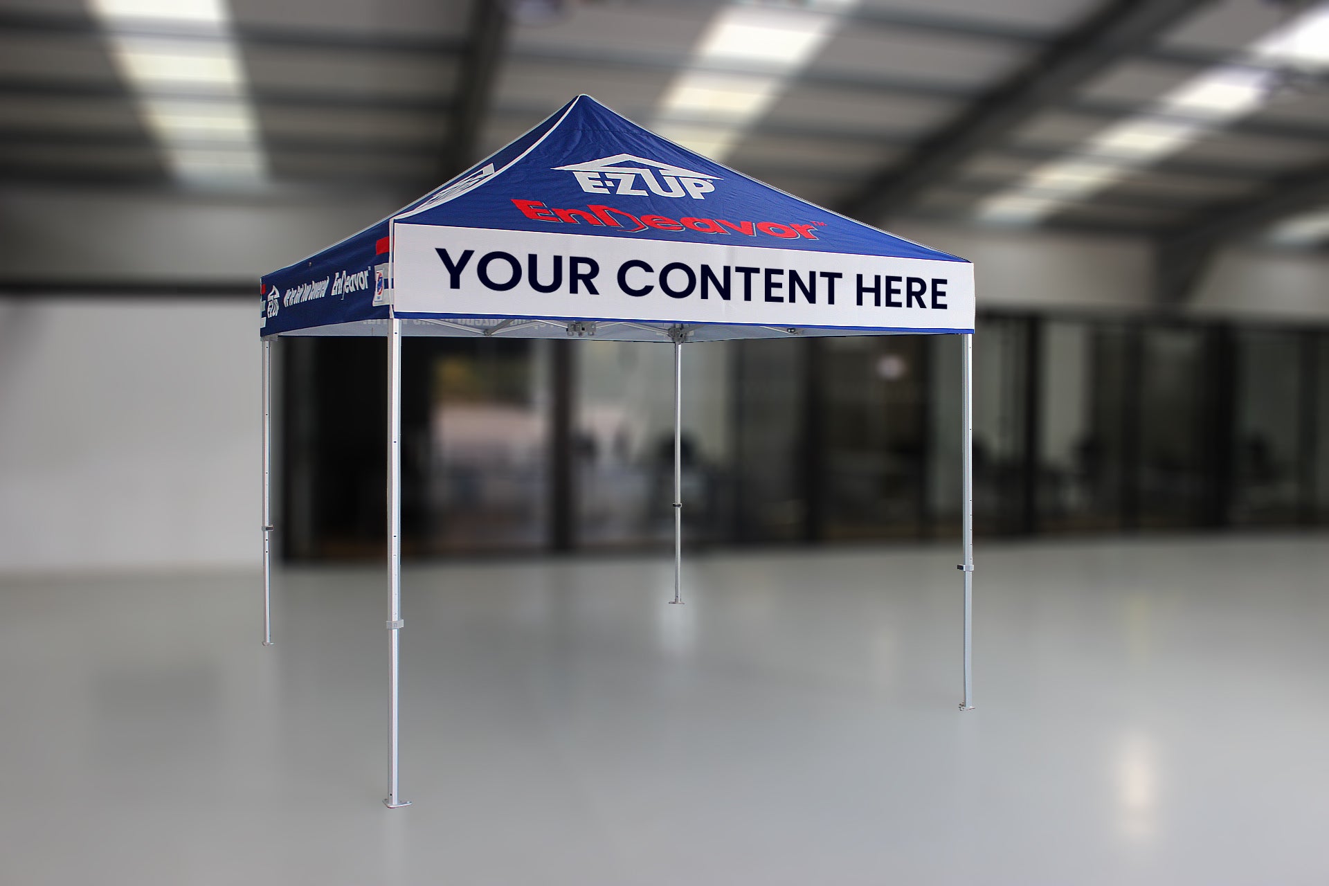 Customizable event tent with Ezup logo and customizable text area in a warehouse setting
