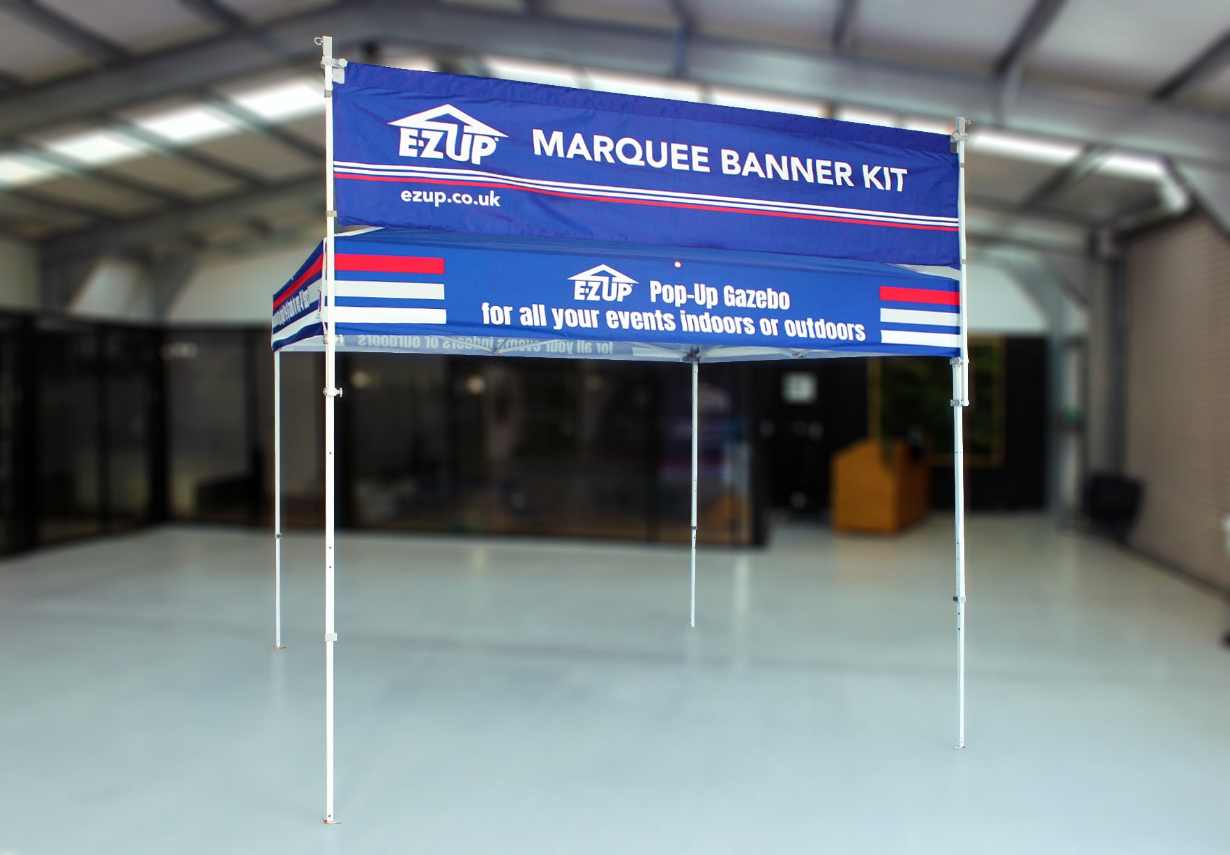 E-Z UP marquee banner kit with branding in a warehouse setting