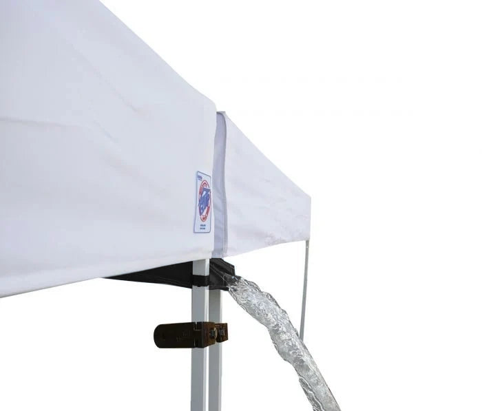 A close-up of a white canopy tent corner with a blue trim and a metal support pole, showing a clear water stream draining from the corner against a white background.